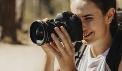 Nahaufnahme einer Frau, die die Landschaft mit einer Digitalkamera fotografiert. Fotografin, die mit einer professionellen Kamera die Landschaft filmt. - JLPSF17392