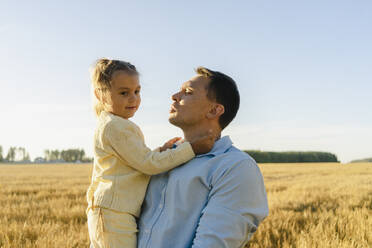 Mann mit Tochter auf einem Feld bei klarem Himmel an einem sonnigen Tag - SEAF01394