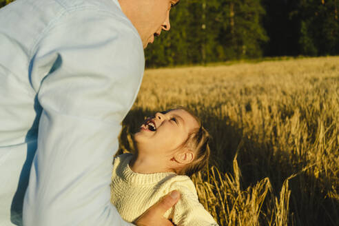 Glückliches Mädchen spielt mit Tochter auf einem Feld an einem sonnigen Tag - SEAF01406