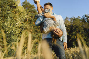 Happy father having fun with daughter at field - SEAF01417