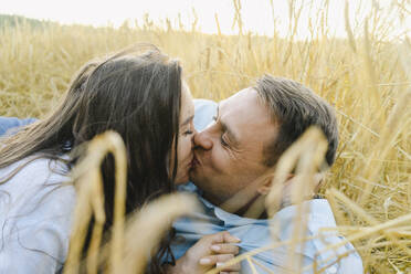 Romantisches Paar, das sich inmitten von Feldfrüchten küsst - SEAF01429