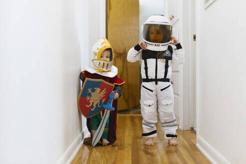 Kleiner Junge (2-3) im Ritterkostüm und Mädchen (2-3) im Astronautenkostüm spielen zu Hause - TETF01832