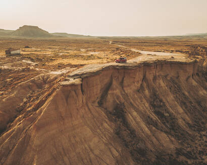 Luftaufnahme eines roten Autos auf einer Klippe, Bardenas Reales, Navarra, Spanien. - AAEF16036