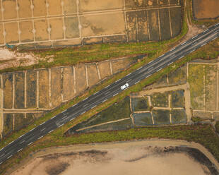 Aerial view of a vehicle driving on the road at the Guerande Salt Marshes, Brittany region, France. - AAEF16117