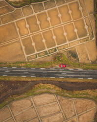 Luftaufnahme eines Fahrzeugs auf der Straße in den Salzgärten von Guerande, Region Bretagne, Frankreich. - AAEF16120