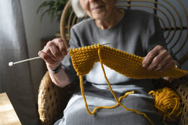 Hände einer älteren Frau beim Stricken eines Schals zu Hause - SVKF00665