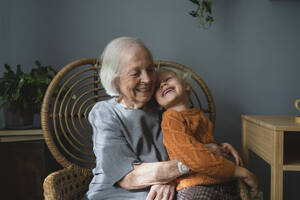 Glückliche Großmutter mit Enkelin, die sich zu Hause amüsiert - SVKF00674