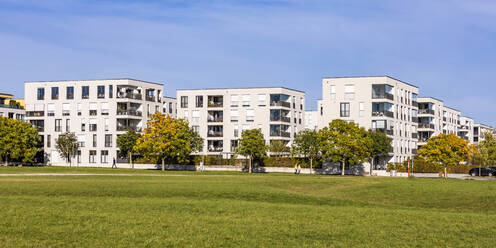 Deutschland, Baden-Württemberg, Ostfildern, Rasen vor modernen Wohnhäusern im Herbst - WDF07104