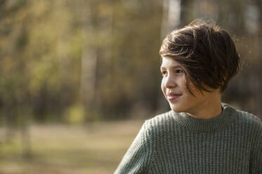 Smiling boy wearing sweater in park - ANAF00253