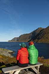 Freunde mit Blick auf das Meer an einem sonnigen Tag - AMNF00063