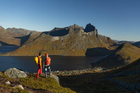 Mature couple standing on top of mountain admiring view - AMNF00073