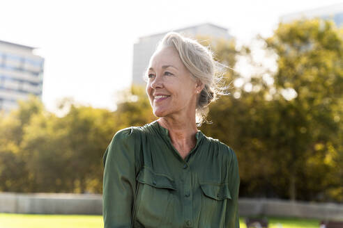 Lächelnde reife Frau mit grauem Haar im Park - OIPF02498
