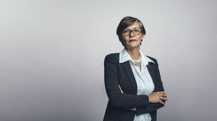 Senior woman entrepreneur in formal business wear. Senior businesswoman isolated on grey background looking at camera. - JLPSF17895