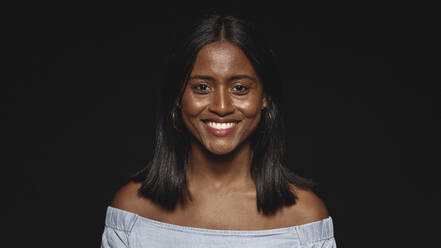 Close up of a cheerful woman isolated on black background. Portrait of a smiling woman looking at camera. - JLPSF17995