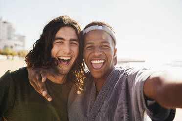 Zwei gemischtrassige männliche Freunde, die an einem Sommertag draußen ein Selfie machen. - JLPSF18043