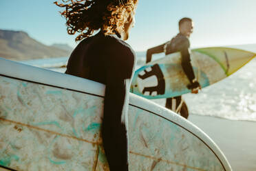 Zwei junge Männer mit Surfbrett gehen zum Surfen im Meer. Surfer mit Surfbrettern laufen am Strand. - JLPSF18066