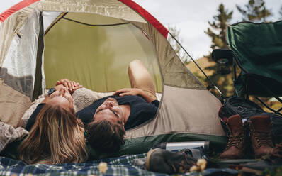 Mann und Frau liegen zusammen in einem Zelt. Ein Paar schläft in einem Zelt auf dem Campingplatz. - JLPSF18169