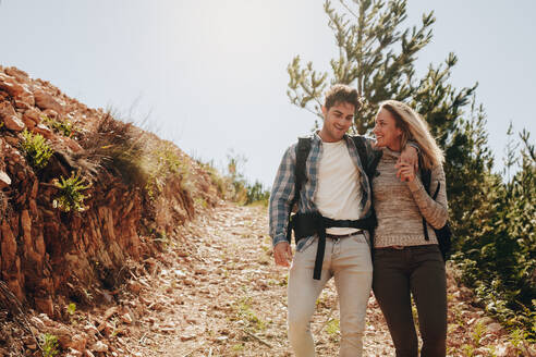 Loving young couple walking down the mountain trail and smiling. Caucasian couple having fun on hiking day. - JLPSF18214