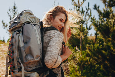 Frau mit Rucksack auf Wanderung in der Natur. Weibliche Wanderin auf Bergpfad und mit Blick auf eine Aussicht. - JLPSF18224