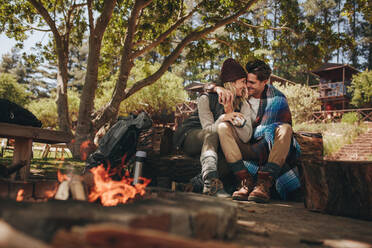 Verliebtes Paar sitzt am Lagerfeuer auf dem Campingplatz. Mann und Frau in einem romantischen Moment auf dem Campingplatz gefangen. - JLPSF18238