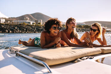 Schöne junge Frauen entspannen sich auf einem privaten Yachtdeck im Meer. Drei Freundinnen sonnen sich auf einer Luxusyacht und haben eine tolle Zeit. - JLPSF18428