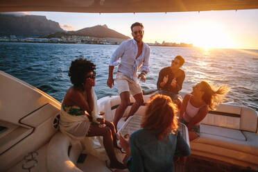 Group of young people dancing in boat party. Multiracial friends having fun in sunset yacht party. - JLPSF18547