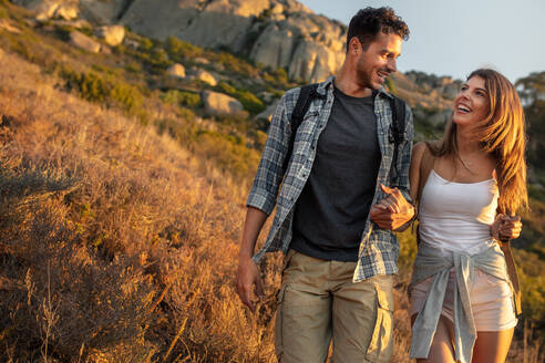 Junger Mann mit seiner Freundin beim Wandern auf einem Bergpfad. Glückliches junges Paar beim gemeinsamen Wandern. - JLPSF18655