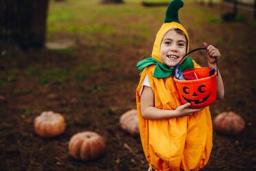 Porträt von niedlichen kleinen Mädchen in Halloween-Kostüm hält Kürbis Eimer im Freien im Park. Kleines Mädchen Kind für Trick oder Behandlung auf Halloween im Freien. - JLPSF18909