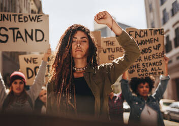 Eine Frau führt eine Gruppe von Demonstranten auf der Straße an. Eine Gruppe von Frauen protestiert für Gleichberechtigung und die Stärkung der Rolle der Frau. - JLPSF18915