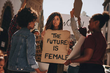 Women protesters hold up signs of the future is female. Group of women protesting outdoors for female empowerment. - JLPSF18922