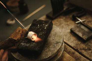 Juwelier lötet und schweißt Metallring am Arbeitsplatz. Schmuckherstellung eines Rings in der Werkstatt. - JLPSF19140