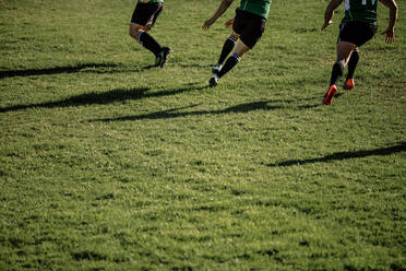 Rugbyspieler, die während eines Spiels auf dem Feld rennen. Füße von professionellen Rugbyspielern, die ein Spiel auf dem Platz spielen. - JLPSF19299
