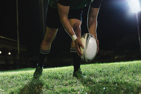 Rugbyspieler, der den Ball zum Schießen auf den Boden fallen lässt, wenn dieser den Boden berührt. - JLPSF19329