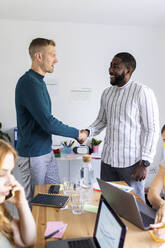 Businessmen doing handshake in meeting at office - WPEF06610