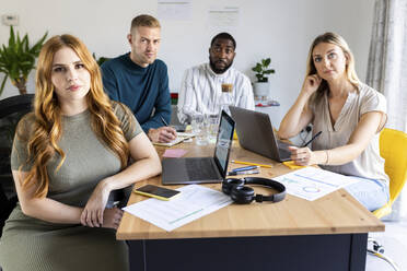 Multiracial businessmen and businesswomen at desk in office meeting - WPEF06612