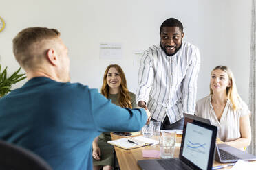 Young businessman shaking hand with colleague in office meeting - WPEF06619