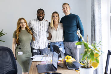 Lächelnde multirassische Kollegen, die gemeinsam im Büro stehen - WPEF06633