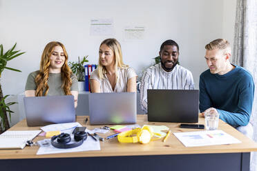 Multirassischer Geschäftskollege mit Laptops auf dem Schreibtisch im Büro - WPEF06667