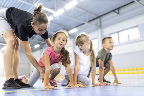 Lehrerin instruiert Mädchen an der Startlinie des Schulsportplatzes - WESTF25169