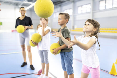 Grundschüler spielen auf dem Schulsportplatz mit einem Ball - WESTF25177