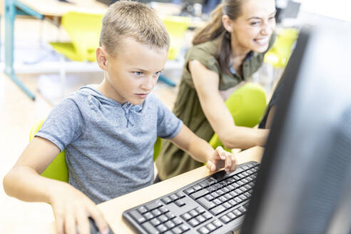 Konzentrierter Junge am Computer in der Schule - WESTF25194