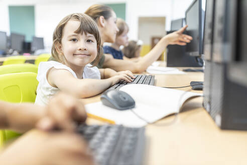 Lächelnder Schüler im Computerkurs in der Schule - WESTF25200