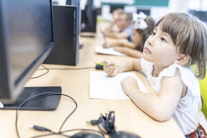 Grundschülerin schaut auf den Bildschirm im Klassenzimmer - WESTF25224