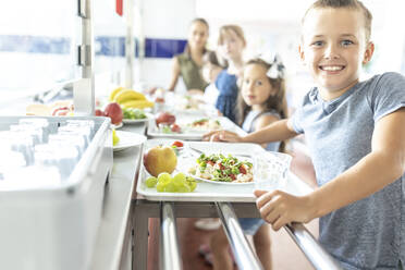 Glücklicher Schüler mit gesundem Essen in der Mittagspause - WESTF25249