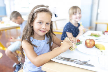 Studentin isst gesundes Sandwich in der Mittagspause in der Cafeteria - WESTF25257