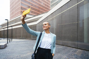 Smiling businesswoman taking selfie through smart phone - OIPF02521