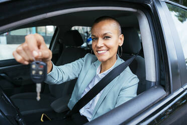 Smiling businesswoman showing car key - OIPF02527