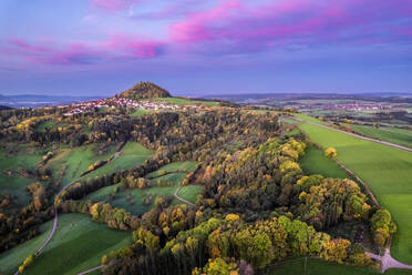 Deutschland, Baden-Württemberg, Drohnenansicht eines Herbsthains in der stimmungsvollen Abenddämmerung mit dem Hohenstaufen im fernen Hintergrund - STSF03583