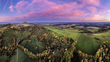 Deutschland, Baden-Württemberg, Drohnenansicht eines Herbsthains in der stimmungsvollen Abenddämmerung mit dem Hohenstaufen im fernen Hintergrund - STSF03584