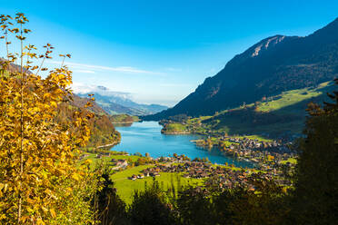 Switzerland, Obwalden, Lungern, View of lakeshore town in autumn - TAMF03555